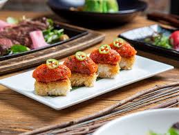 Sunda New Asian signature dishes Crispy Rice with Spicy Tuna, Oxtail Pot Stickers, "The Rock" (Wagyu Beef), Miso-Glazed Black Cod